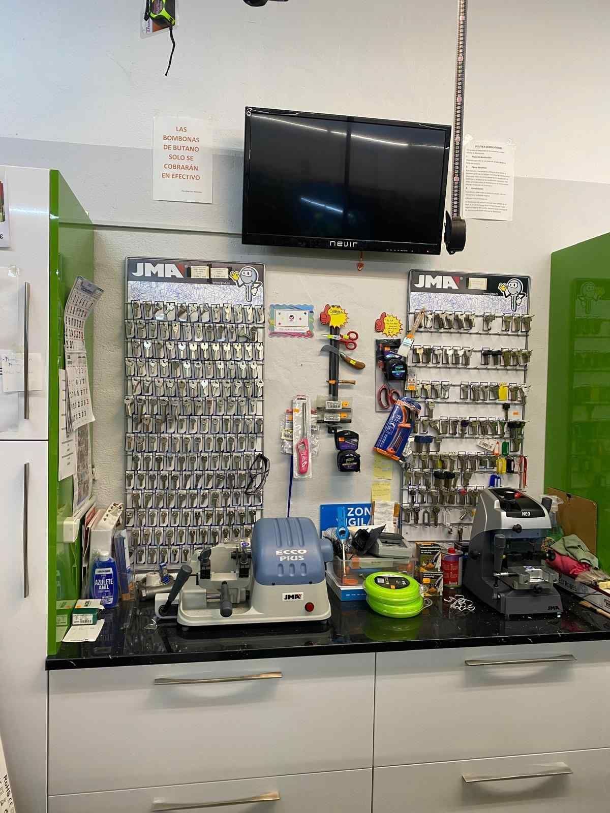 Interior de una tienda de duplicado de llaves con tableros para llaves, máquinas, herramientas