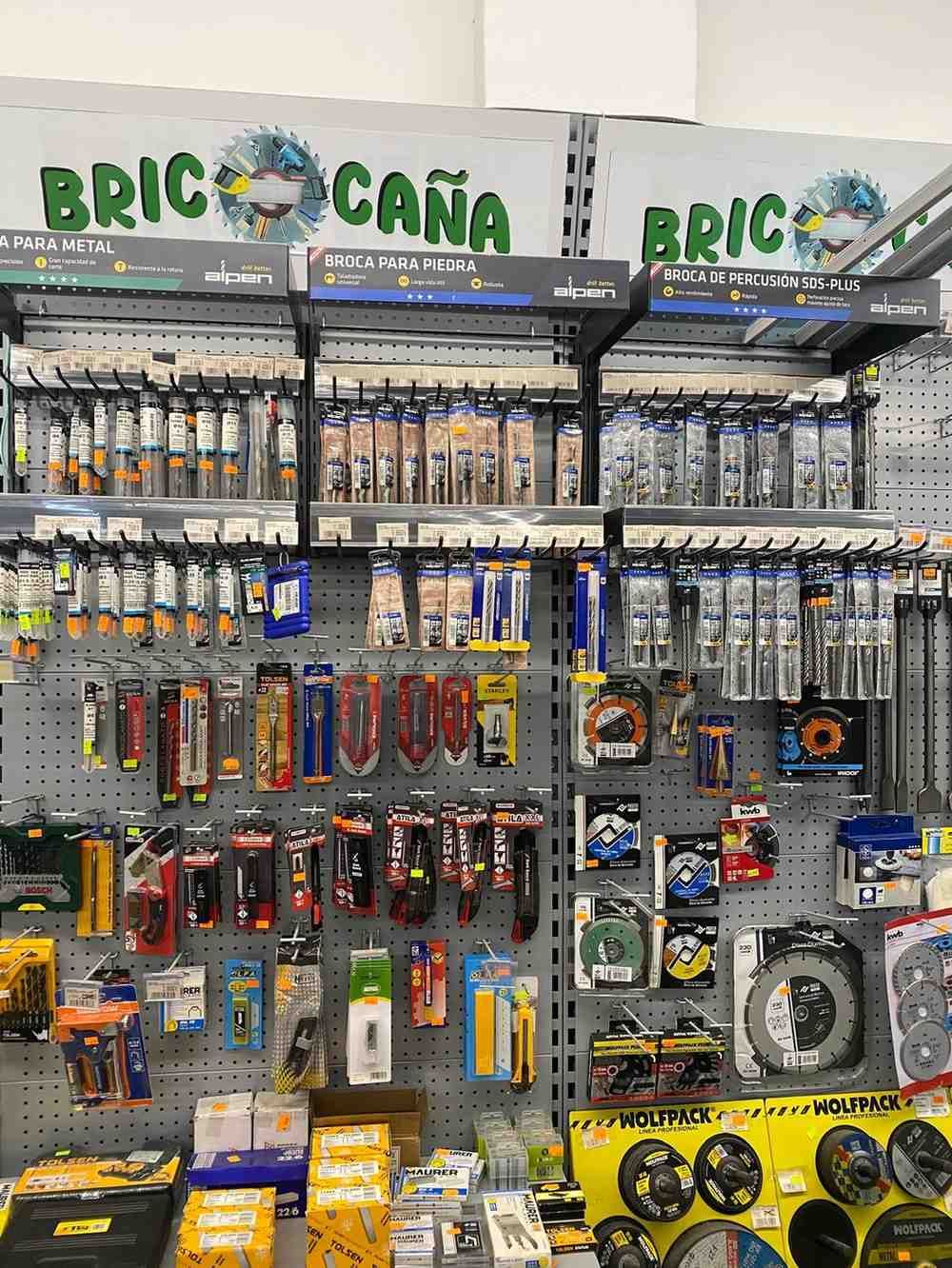 Exhibición de ferretería con herramientas, incluidos destornilladores, hojas y hojas de sierra circular, bajo el letrero 