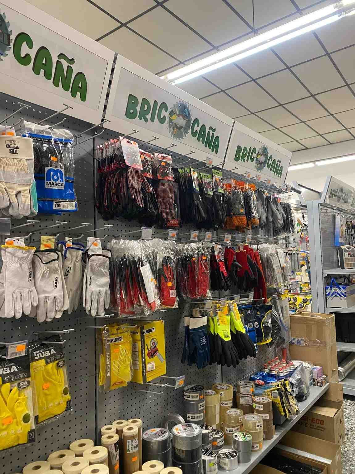 Guantes y herramientas expuestos en estanterías de una ferretería 