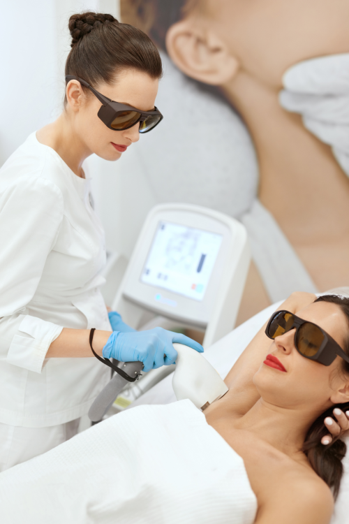 Una mujer que lleva gafas de sol está recibiendo un tratamiento con láser en la cara.