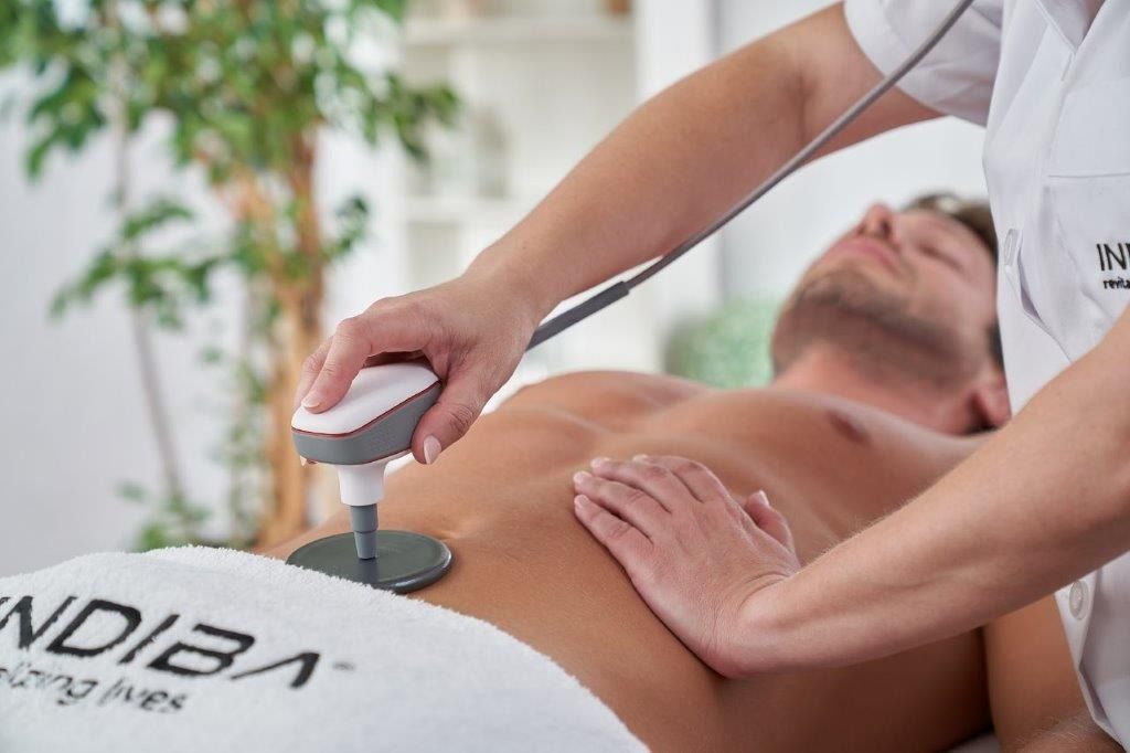 Un hombre está acostado en una mesa recibiendo un masaje de una mujer.