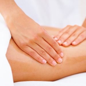 Una mujer está recibiendo un masaje con las manos sobre su estómago.