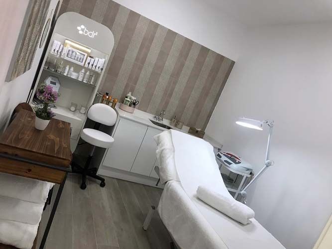 Una habitación con una cama, silla, mesa y espejo.