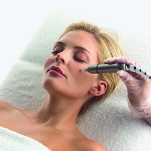 Una mujer está acostada en una cama recibiendo un tratamiento en su cara.