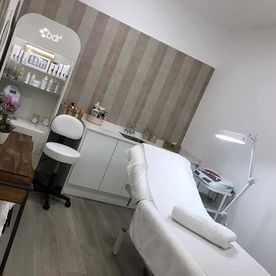 Una habitación con una cama, silla, mesa y lámpara.