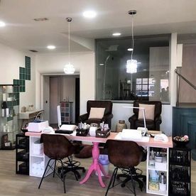 Una habitación con una mesa y sillas de color rosa.