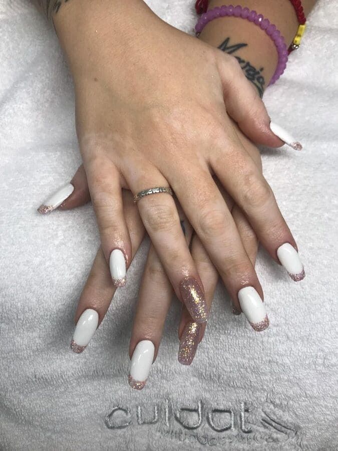 Un primer plano de las manos de una mujer con largas uñas blancas.