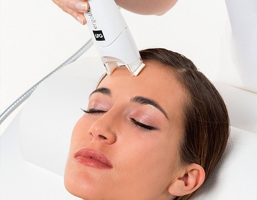 Una mujer está recibiendo un tratamiento facial con una máquina en la frente.