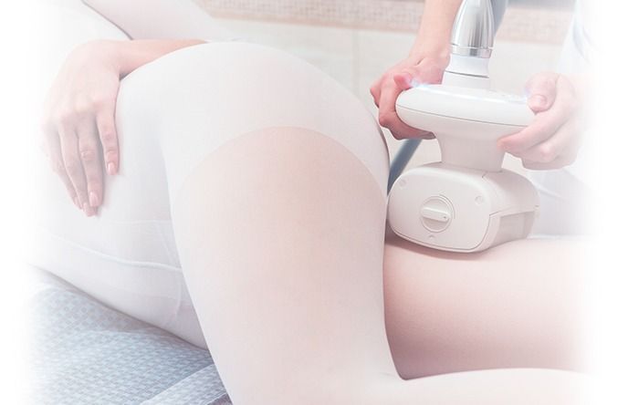 Una mujer está recibiendo un masaje en su pierna con una máquina.