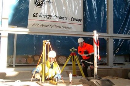 Zwei Männer arbeiten vor einem Schild mit der Aufschrift GE Energy Products Europe