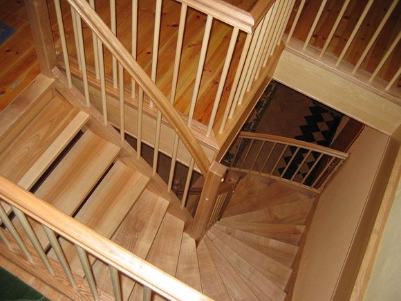 Eine hölzerne Wendeltreppe mit einem weißen Geländer