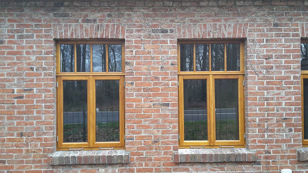 An der Seite eines Backsteingebäudes befinden sich zwei Fenster.