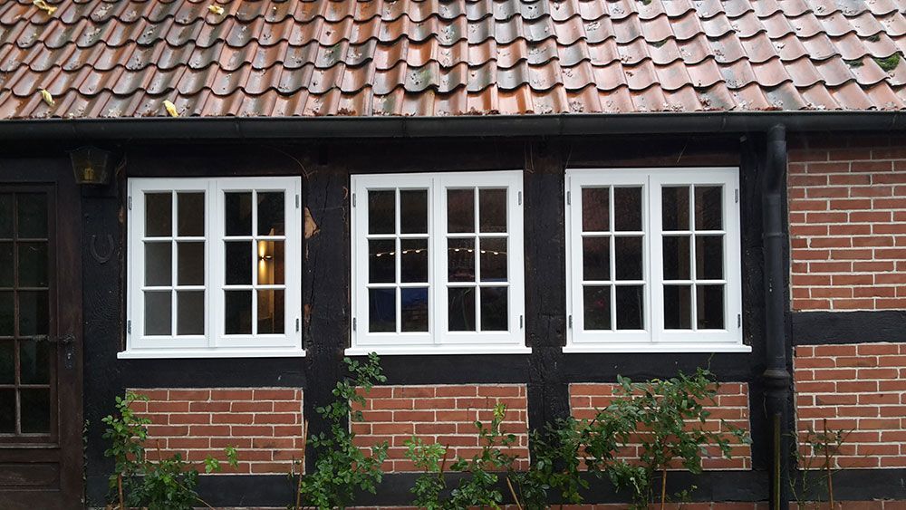 Ein Backsteingebäude mit drei Fenstern und einem Ziegeldach