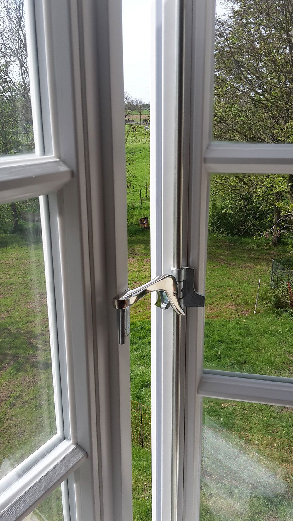 Eine Nahaufnahme eines offenen Fensters mit einem Schlüssel darin.