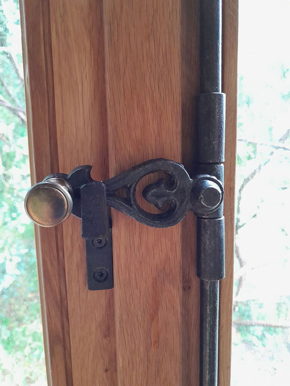 Eine Nahaufnahme einer Holztür mit einem Metallriegel.