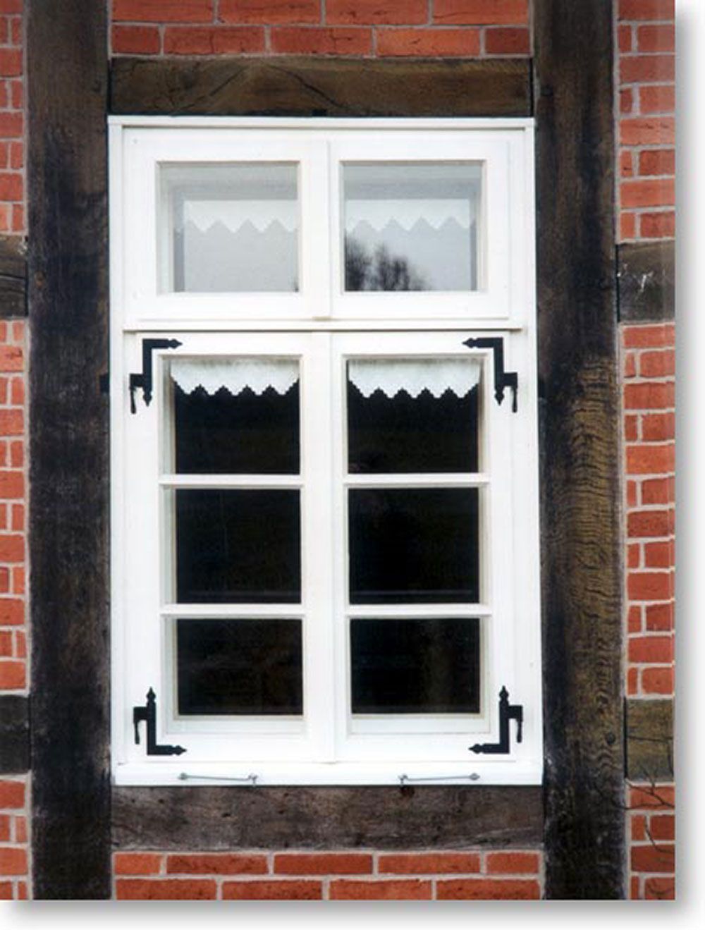 Ein weißes Fenster an einer roten Backsteinmauer