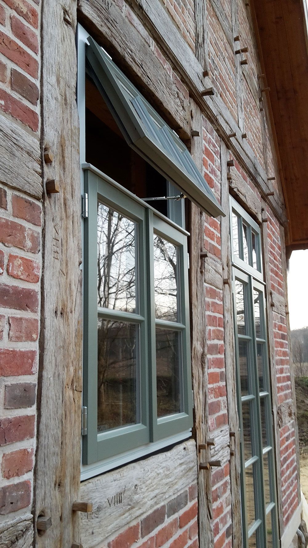 Ein Backsteingebäude mit einem grünen Fenster an der Seite.
