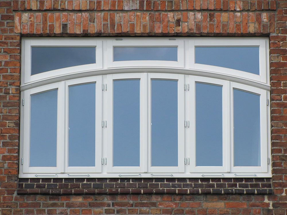 Ein großes weißes Fenster an einer Backsteinmauer