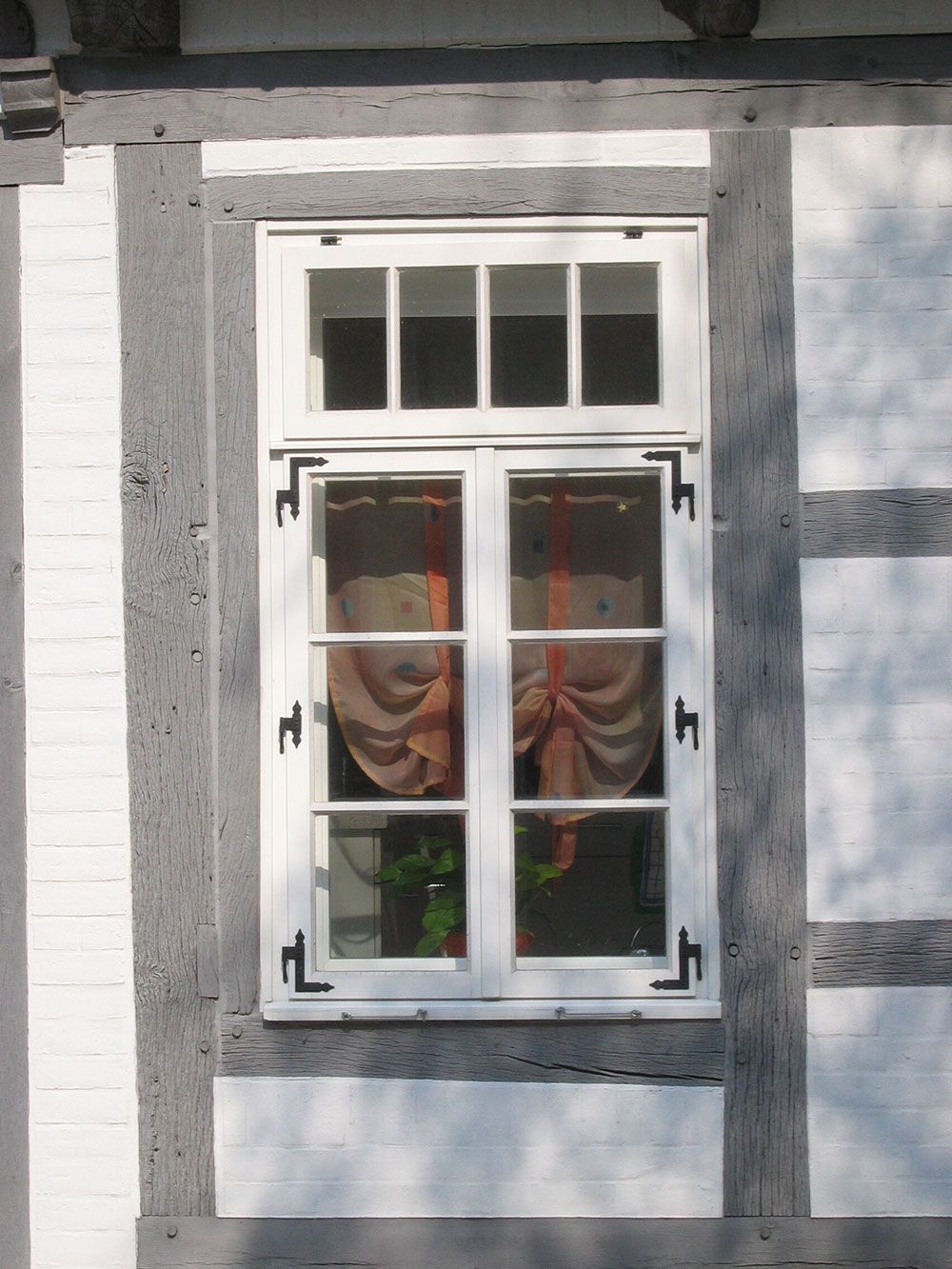 Ein weißes Fenster mit einem Holzrahmen an einem Gebäude
