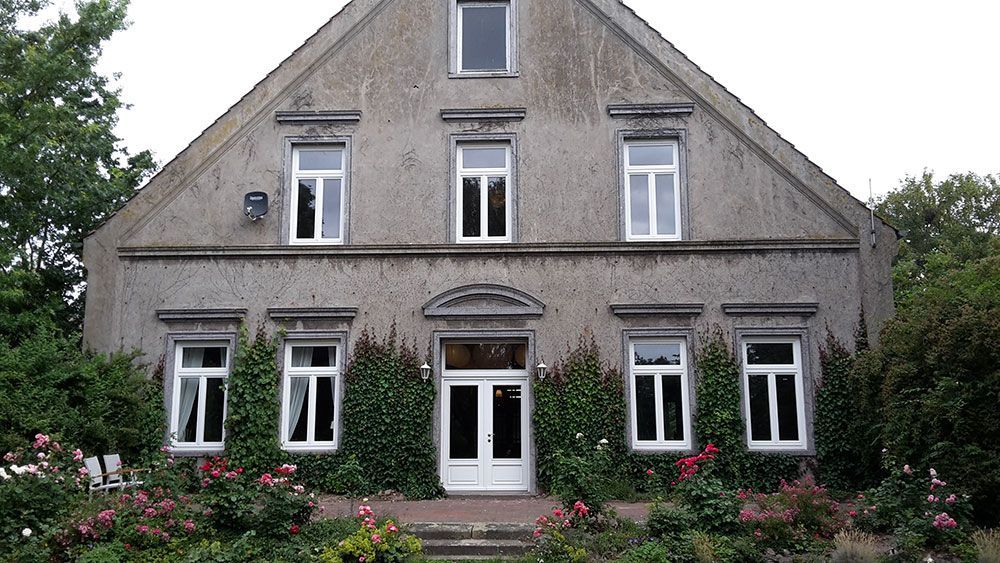 Ein großes Haus mit vielen Fenstern und Blumen davor