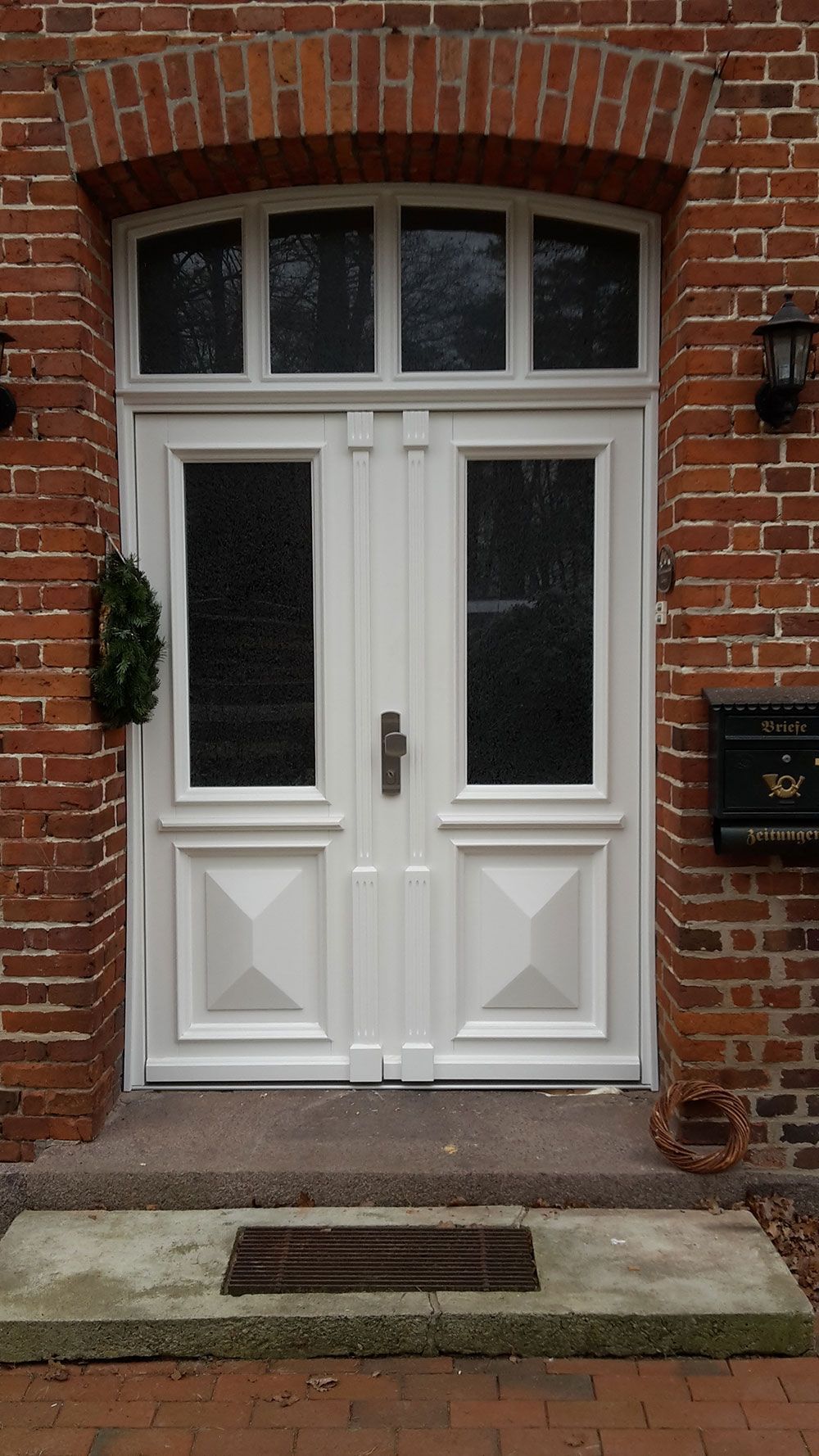 Eine weiße Tür ist auf einem roten Backsteingebäude