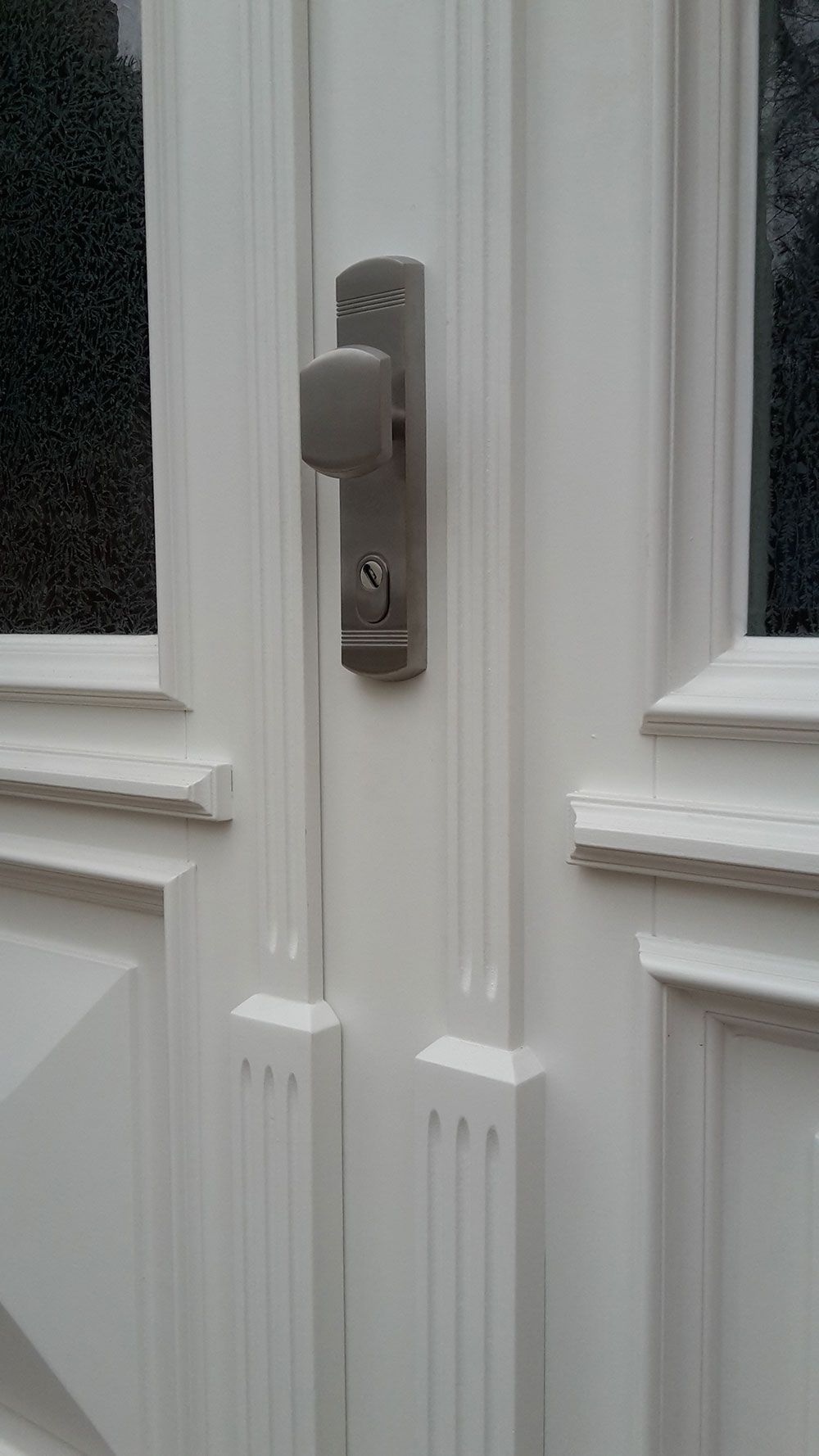 Eine Nahaufnahme einer weißen Tür mit einem Schlüssel daran.