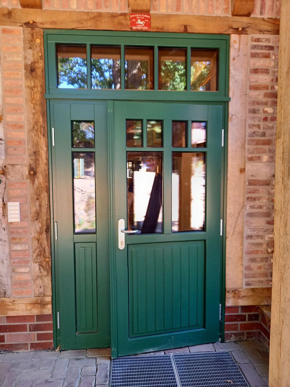 Eine grüne Tür mit einer Ziegelwand dahinter