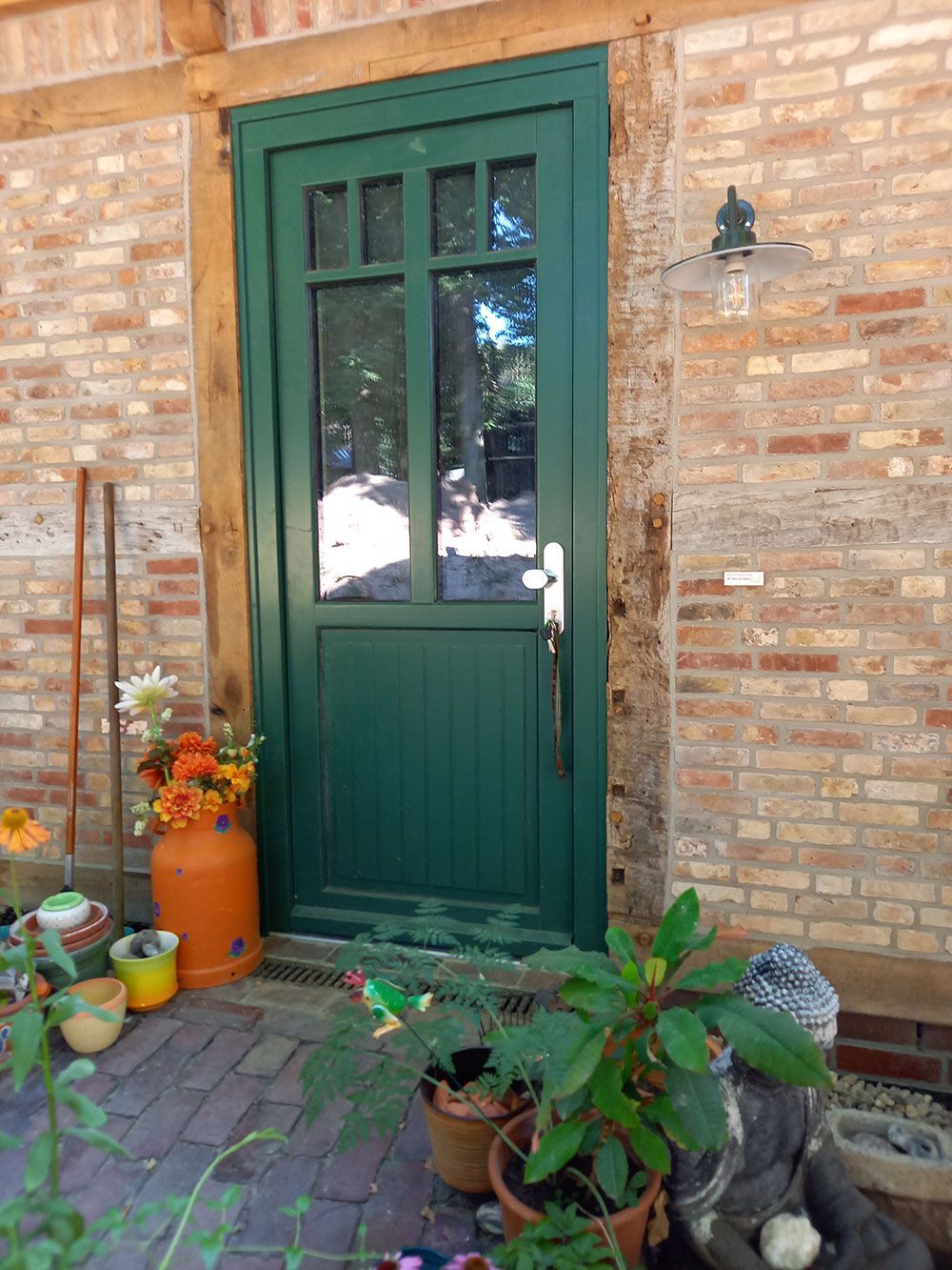 Eine grüne Tür mit einer Ziegelwand dahinter