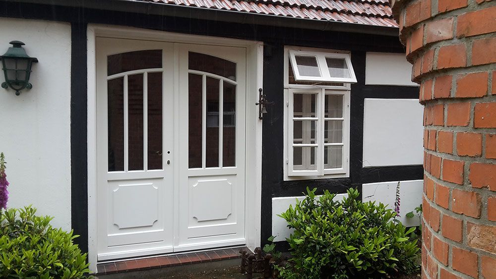 Ein schwarz-weißes Haus mit einer weißen Tür und einem weißen Fenster