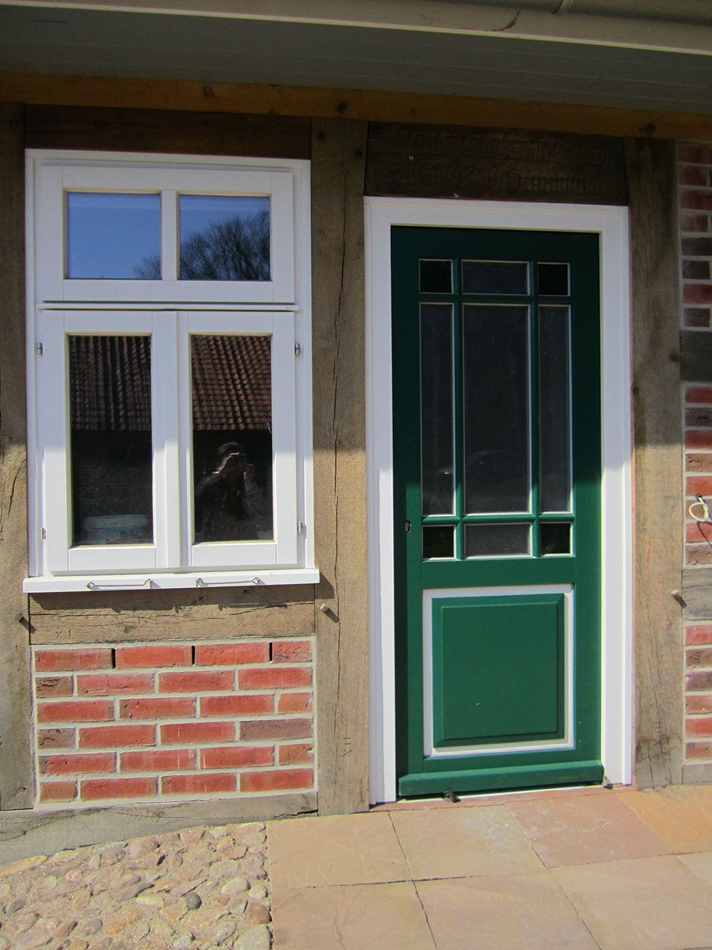 Ein Backsteingebäude mit einer grünen Tür und einem weißen Fenster