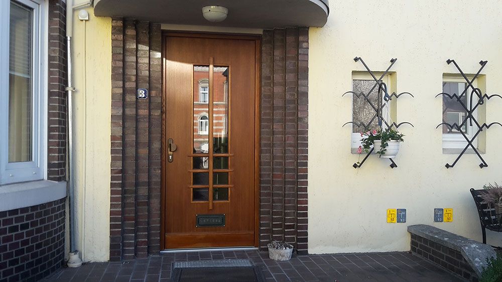 Die Eingangstür eines Backsteingebäudes mit einer Holztür