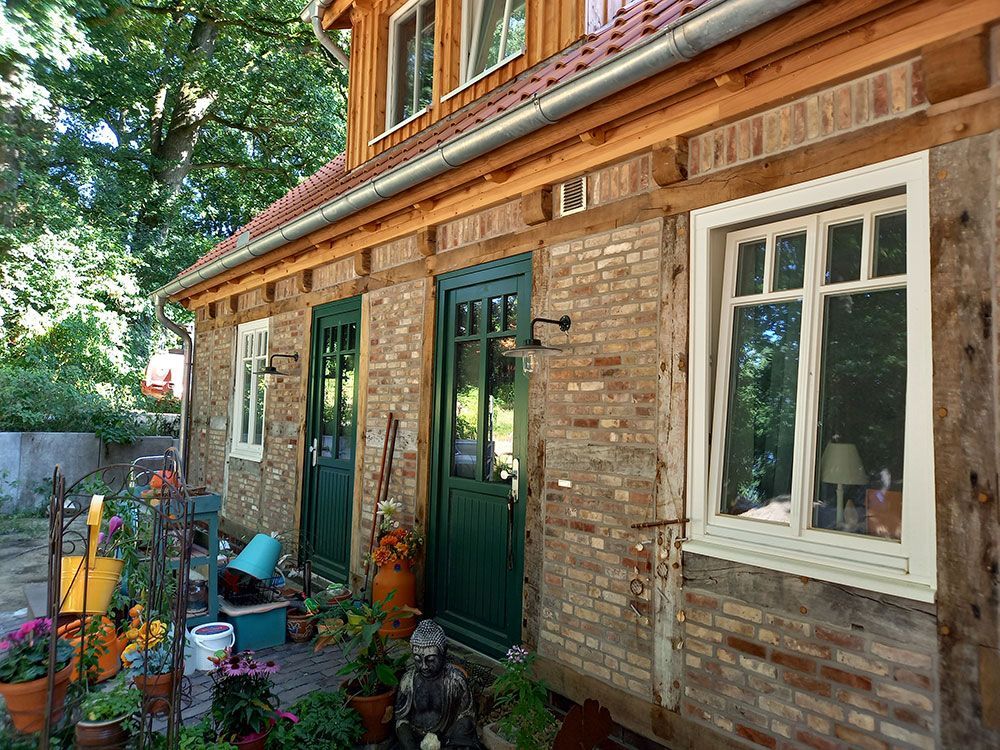 Ein Backsteinhaus mit einer grünen Tür und einem weißen Fenster
