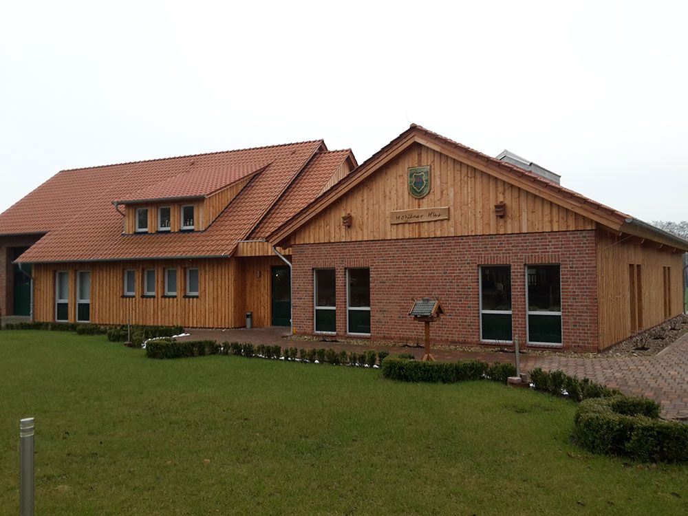 Ein großes Holzhaus mit einem roten Ziegeldach