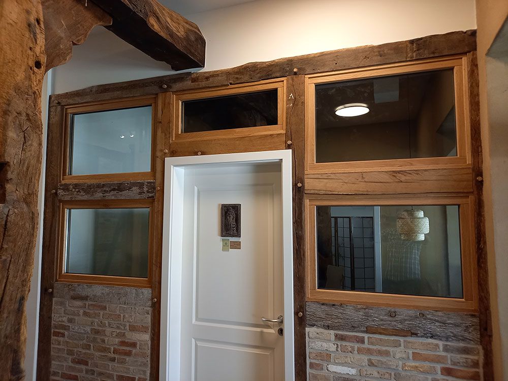 Ein Raum mit einer Ziegelwand und einer Tür mit vielen Fenstern.