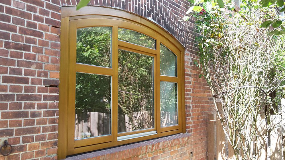 An der Seite eines Backsteingebäudes befindet sich ein Holzfenster.