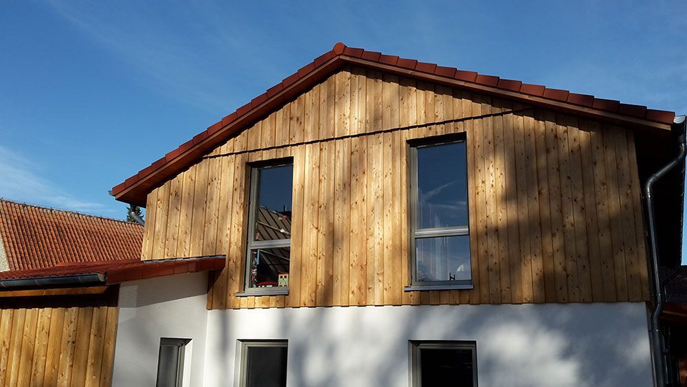 Ein Haus mit einer Holzverkleidung und einem roten Dach