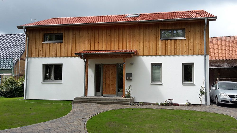 Ein weißes Haus mit einem davor geparkten Auto