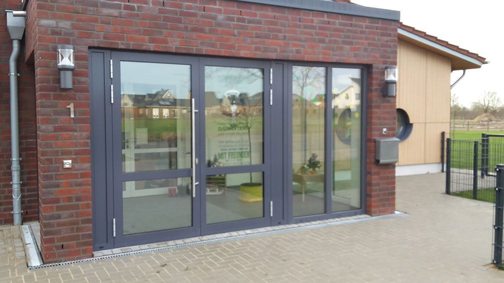 Ein Backsteingebäude mit einer großen Glastür und einem Briefkasten.