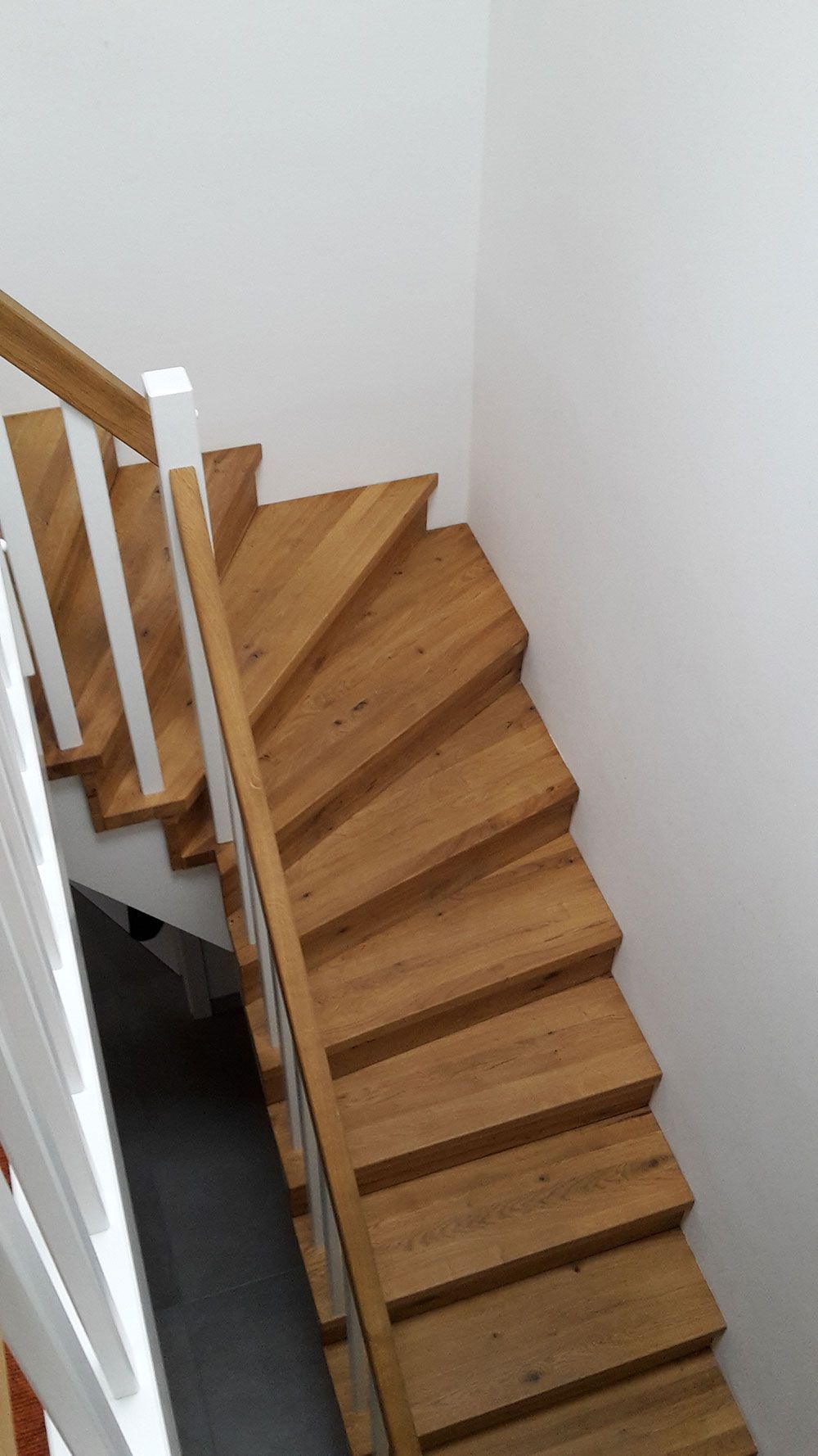 Eine Luftaufnahme einer Holztreppe mit einem weißen Geländer.