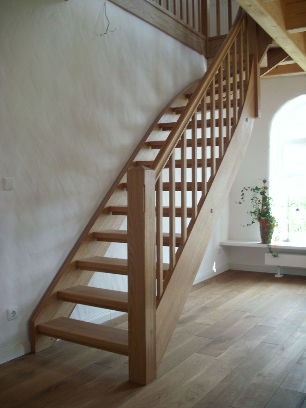 Eine Holztreppe mit einem Fenster im Hintergrund