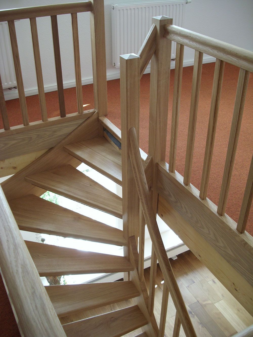 Eine hölzerne Wendeltreppe mit Geländer in einem Raum