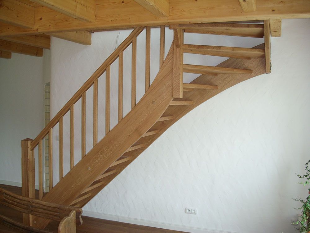 Eine Holztreppe in einem Raum mit einer weißen Wand