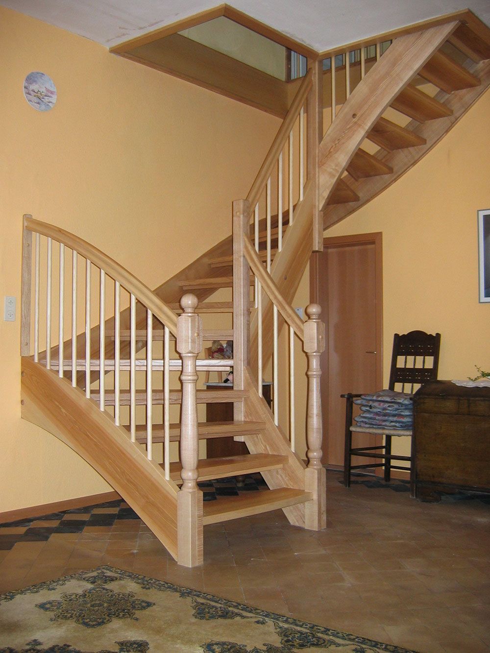 Eine Holztreppe mit weißem Geländer in einem Wohnzimmer