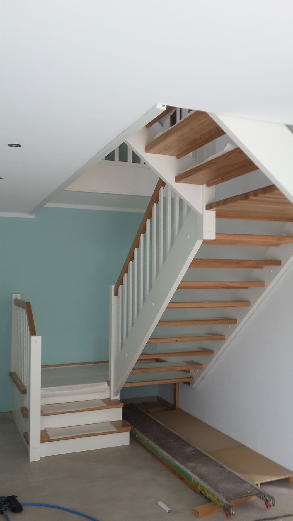 In einem Raum wird eine Holztreppe eingebaut.