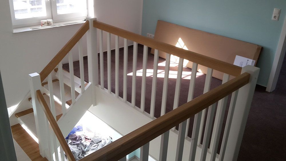 Eine Treppe mit einem Holzgeländer und einem weißen Geländer