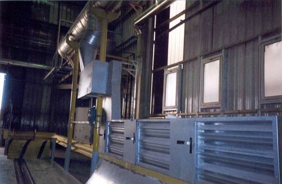 Intérieur d'usine avec machines et ventilations.