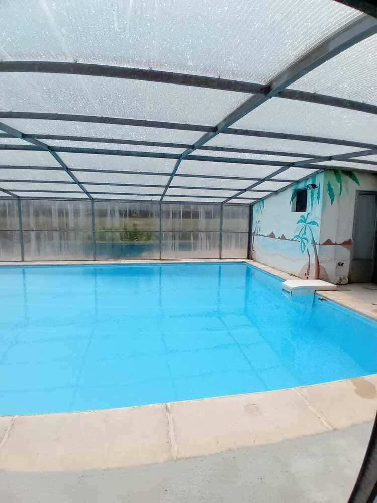 Piscina cubierta con agua azul brillante y techo arqueado translúcido