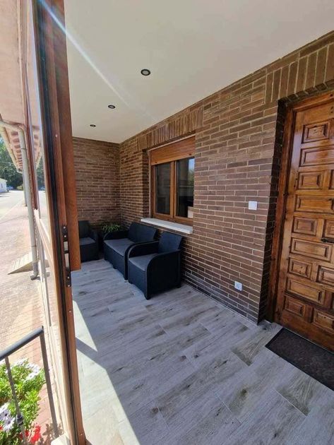 Acogedor salón de piedra con la chimenea encendida, sofás beige, mesa de centro de madera y una ventana con vistas a las montañas