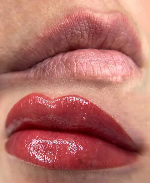 Un primer plano de los labios de una mujer con lápiz labial rojo.