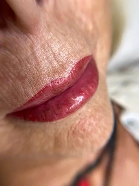 Un primer plano de los labios de una mujer con lápiz labial rojo.